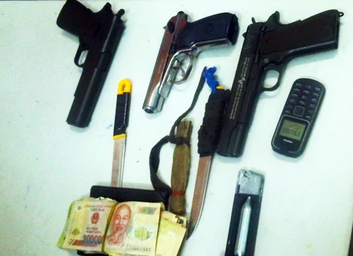 3 khẩu súng ngắn cùng những tang vật liên quan của nhóm cướp bị thu giữ. Ảnh: Hoàng Trường