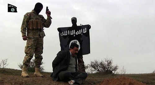 Các phiến quân cầm cờ IS khi hành quyết một người đàn ông trong video tuyên truyền của nhóm. Ảnh: AP