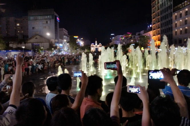 Nhiều bạn trẻ chụp ảnh lưu niệm ở khu vực đài phun nước, phố đi bộ Nguyễn Huệ - Ảnh. T.T.D. Nhiều bạn trẻ chụp ảnh lưu niệm ở khu vực đài phun nước, phố đi bộ Nguyễn Huệ - Ảnh. T.T.D.