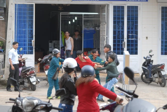 Nữ dân quân tự vệ và một người trong nhóm dân quân tự vệ cố can ngăn vụ ẩu đả nhưng không thành