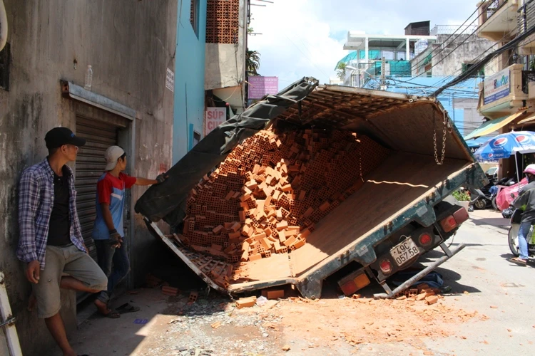 Xe tải sụp hố ga lật chổng vó giữa phố Sài Gòn ảnh 1