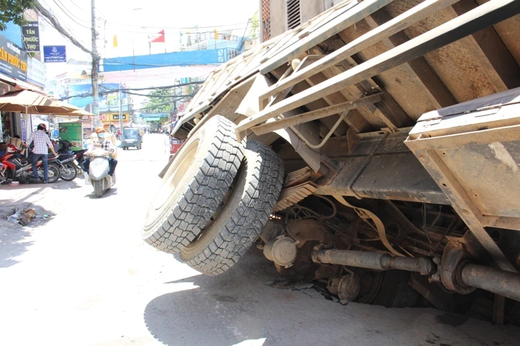 Xe tải sụp hố ga lật chổng vó giữa phố Sài Gòn ảnh 2