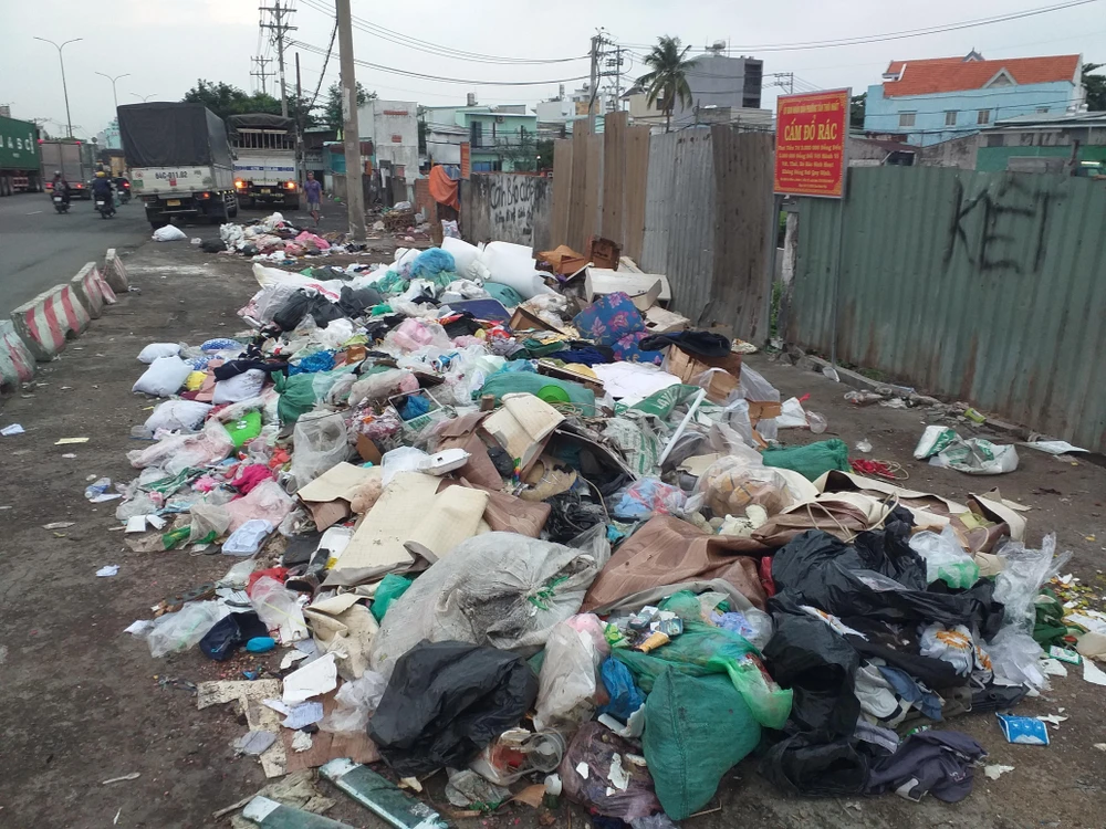 Dù UBND phường đã cắm bảng cấm, nhiều người vẫn đem rác ra vứt ở bên lề Quốc lộ 1A (gần số 2963-2965, QL 1A, phường Tân Thới Nhất, quận 12, TP.HCM). Ảnh: TRẦN ĐĂNG QUANG