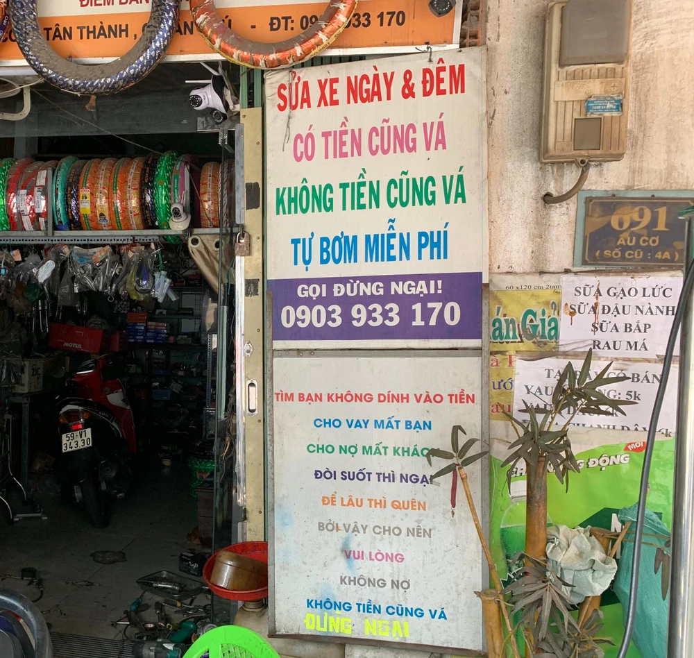 Tấm biển ở tiệm sửa xe của ông Vinh đã treo lâu ngày, gần đây gây xúc động cộng đồng mạng. Ảnh: YÊN MY