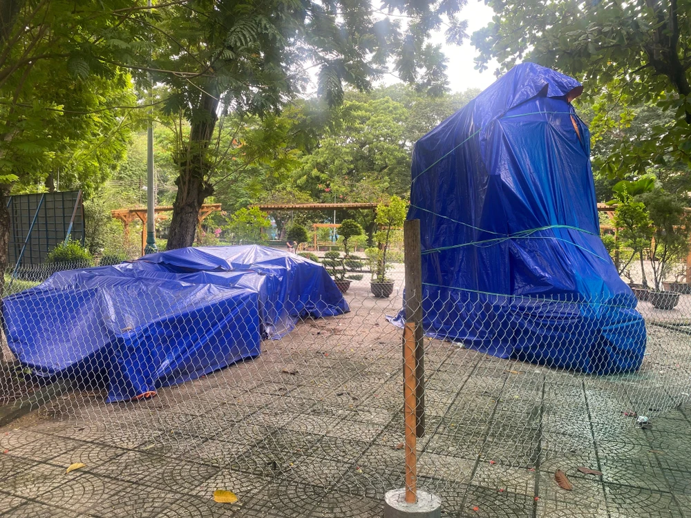 Tượng Trần Nguyên Hãn (dựng đứng) và Lê Lợi (nằm) phủ bạt xanh trong 1 góc công viên Phú Lâm, quận 6. Ảnh: LƯU ĐỨC