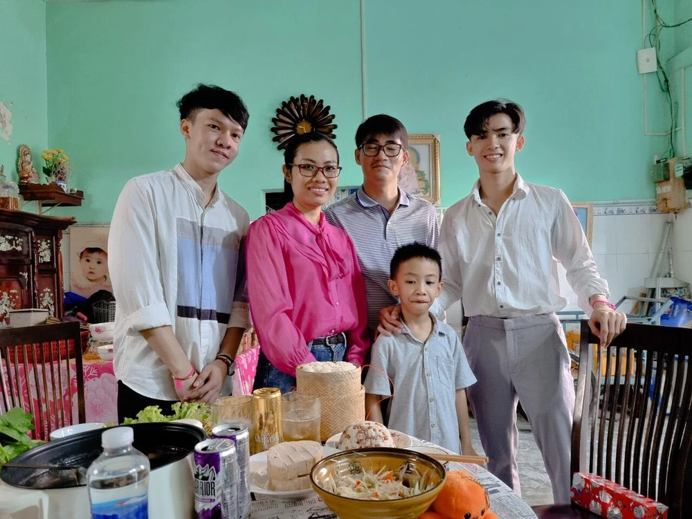 Hai sinh viên Sengchan Avouy và Douangnapha vui vẻ bên gia đình người Việt Nam (phường Đa Kao, quận 1)