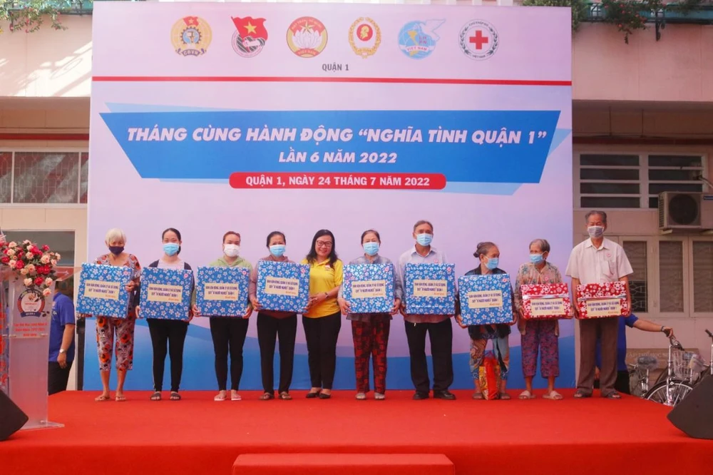Bà Phạm Thị Ngọc Minh, Phó Chủ tịch Ủy ban MTTQ Việt Nam quận 1 trao quà cho hộ dân thuộc diện khó khăn, nghèo, cận nghèo. Ảnh: NGỌC TRĂM
