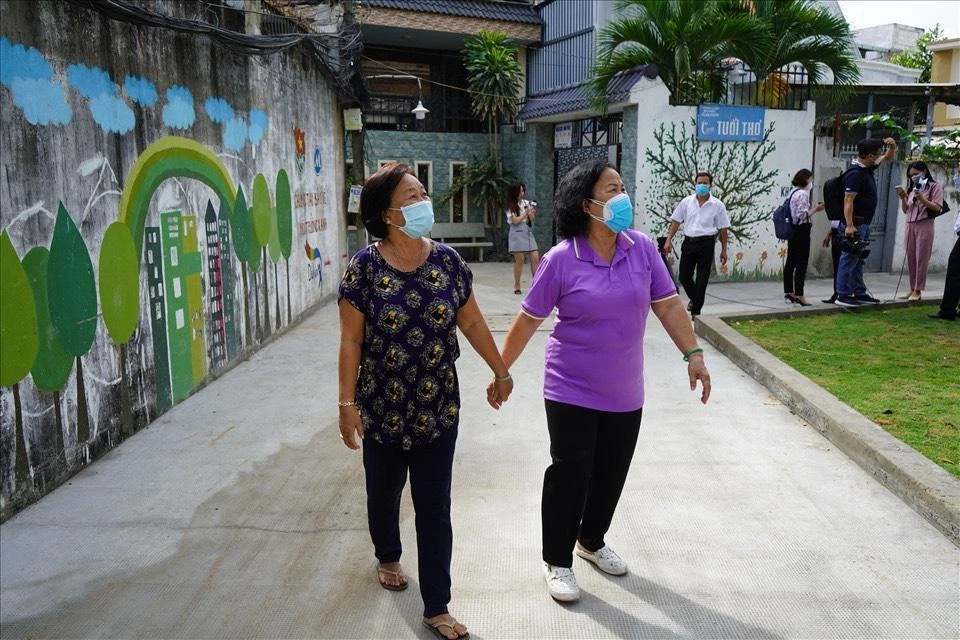 Bà Trần Thị Thanh (sống tại hẻm 1205 Huỳnh Tấn Phát, quận 7, TP.HCM) cùng hàng xóm vui mừng vì hẻm được khang trang. Ảnh: HUỲNH THƠ