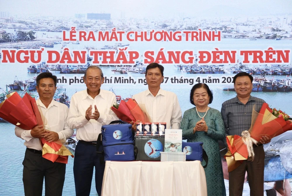 Bà Trương Mỹ Hoa, nguyên Phó Chủ tịch nước, Chủ tịch Quỹ học bổng Vừ A Dính, Chủ nhiệm Câu lạc bộ "Vì Hoàng Sa - Trường Sa thân yêu" và ông Trương Hòa Bình, nguyên Ủy viên Bộ Chính trị, nguyên Phó Thủ tướng thường trực, trao tặng ba bộ quà tặng đầu tiên cho ba hộ gia đình ngư dân trong khuôn khổ chương trình. Ảnh: HOÀNG GIANG