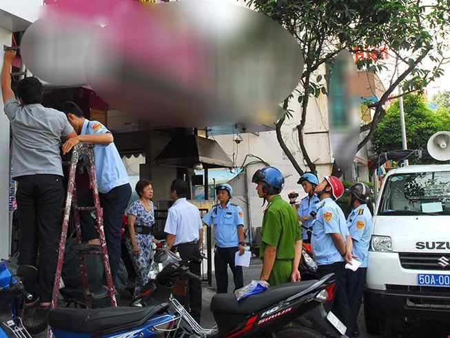 Lực lượng chức năng tháo dỡ biển hiệu vi phạm lấn chiếm không gian chung Lực lượng chức năng tháo dỡ biển hiệu vi phạm lấn chiếm không gian chung