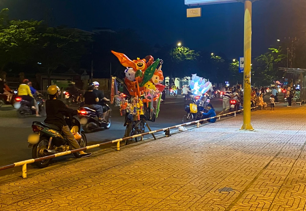 Xe bán đồ chơi, kẹo bông gòn tại một điểm khác của công viên, khu vực đông đúc xe cộ qua lại Ảnh TUYẾT NHUNG.jpg