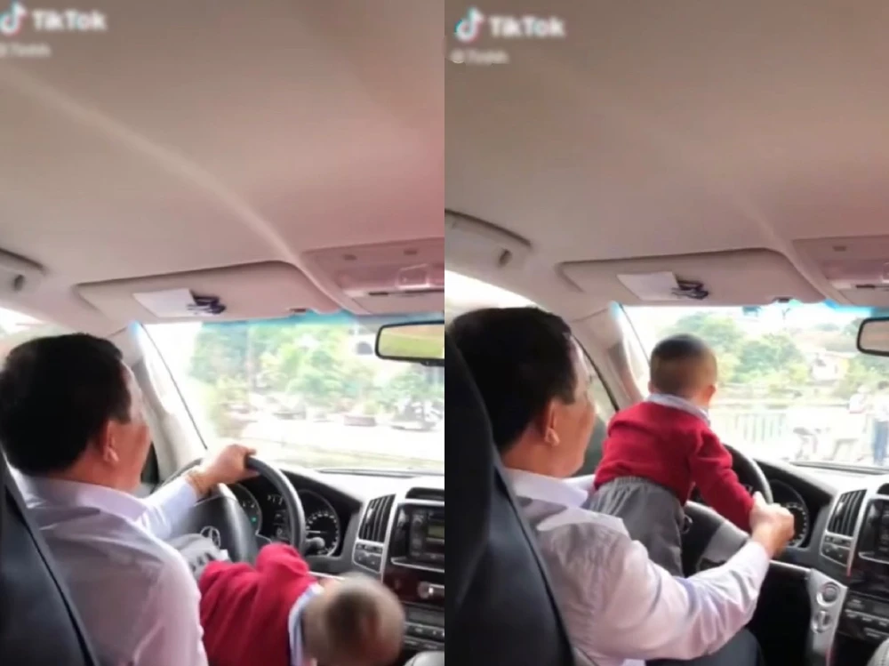 vừa lái xe ô tô vừa ôm trẻ