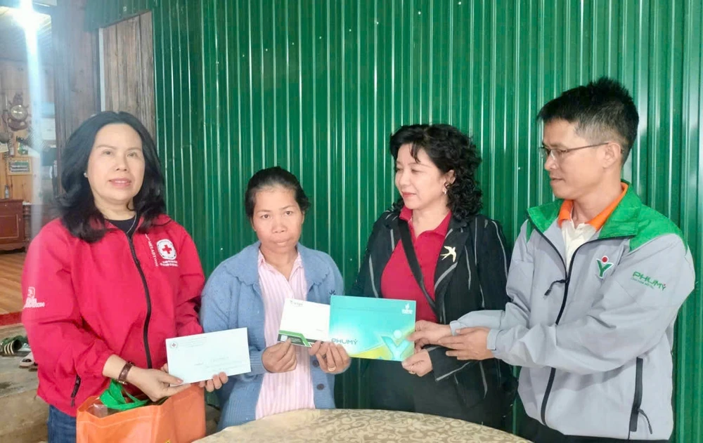 Đại diện mạnh thường quân trao hỗ trợ cho gia đình có người thân gặp nạn do lũ lụt tại tỉnh Lâm Đồng. Ảnh: PHƯƠNG NAM