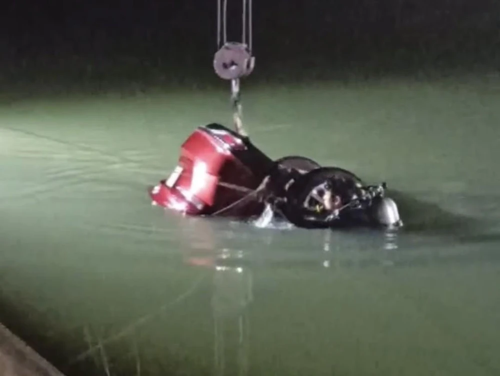 Lực lượng cứu hộ đang trục vớt chiếc xe cùng tài xế xấu số. Ảnh: VT