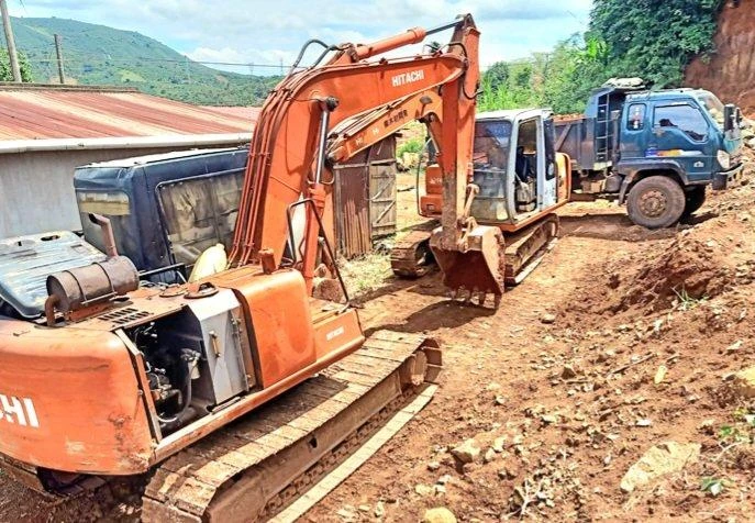 Ba người dùng xe cuốc, xe ben mở đường, múc đất trái phép Ảnh CA