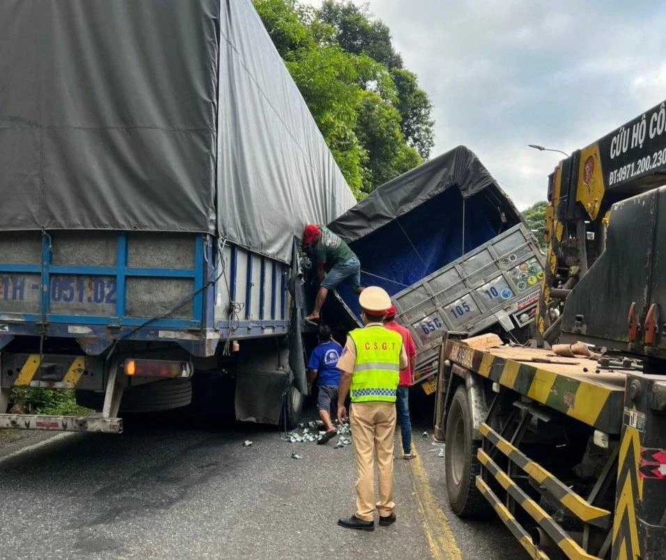 Chiếc xe tải lật nghiêng sau khi sụp ổ gà, gây ách tắc lưu thông. Ảnh: VT