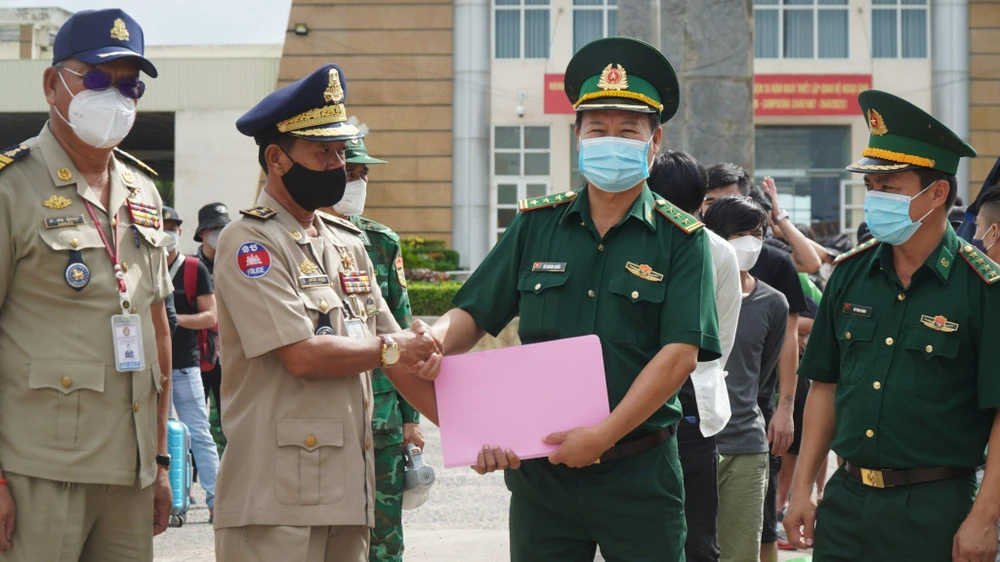 Đại diện hai nước Việt Nam - Campuchia làm thủ tục bàn giao lao động Việt Nam. Ảnh VT