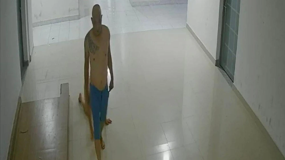 Luân "Chùa" dùng thắt lưng quấn cổ, dắt con đi trong hành lang. Ảnh: Cắt từ clip