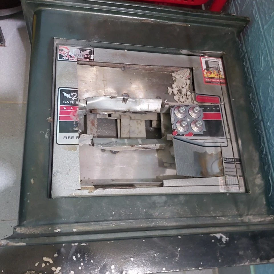 Kiệt cạy phá két sắt để lấy tiền. Ảnh: VÕ TÙNG