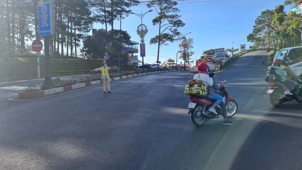 Đội CSGT TP Đà Lạt hướng dẫn người dân trên đầu đèo Prenn hướng từ TP Đà Lạt về huyện Đức Trọng. Ảnh: VÕ TÙNG