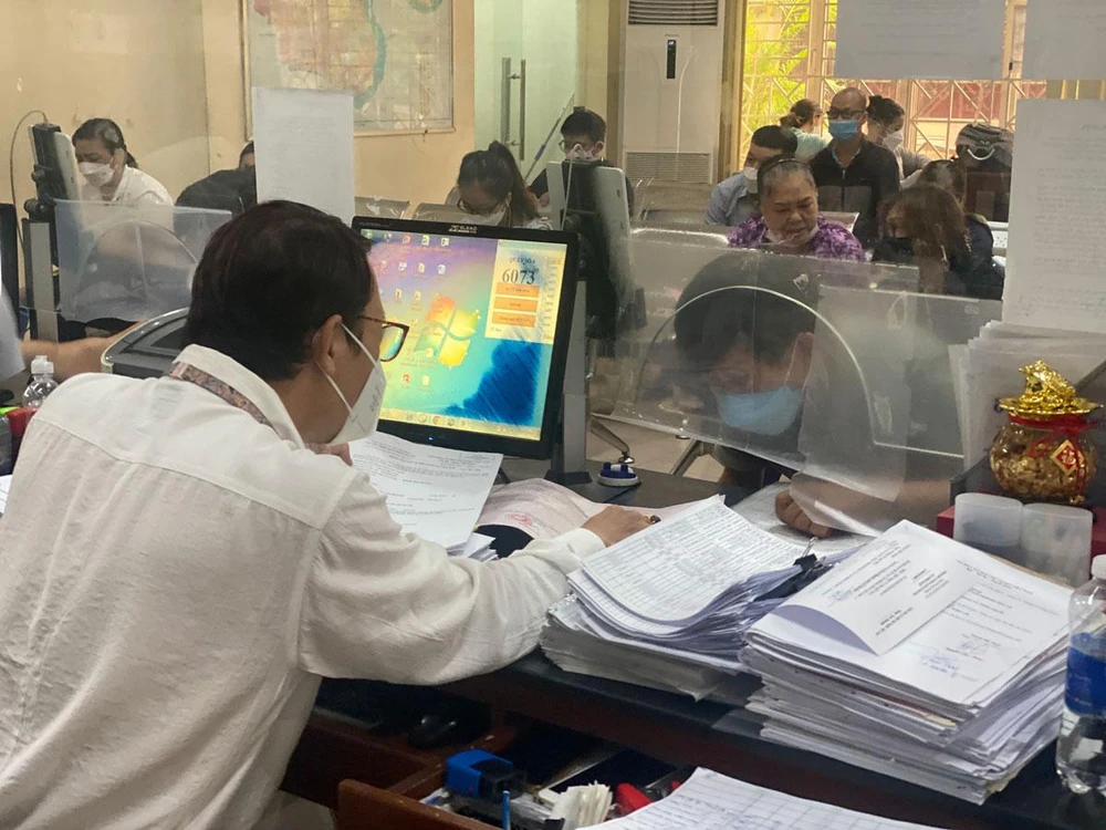 Người dân giải quyết thủ tục hành chính tại UBND quận Bình Thạnh trong ngày đầu thực hiện Tháng hành động. Ảnh: HỮU ĐĂNG