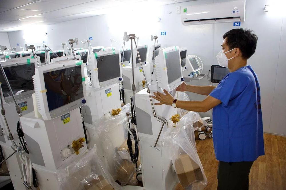 Nhân viên y tế Bv Bạch Mai sắp xếp thiết bị y tế tại Bv dã chiến số 13 (quận 7, TP.HCM). Ảnh: NGUYỆT NHI