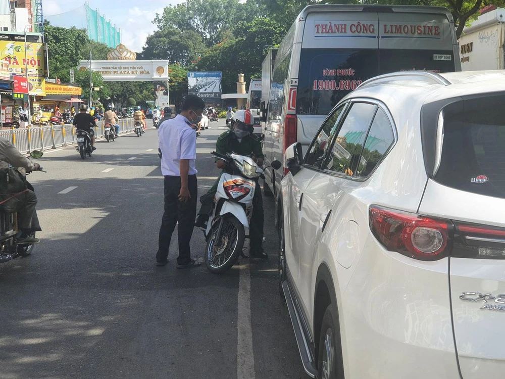 Nhân viên đang thu phí đỗ ô tô dưới lòng đường Lê Hồng Phong, quận 10, TP.HCM. Ảnh: KC