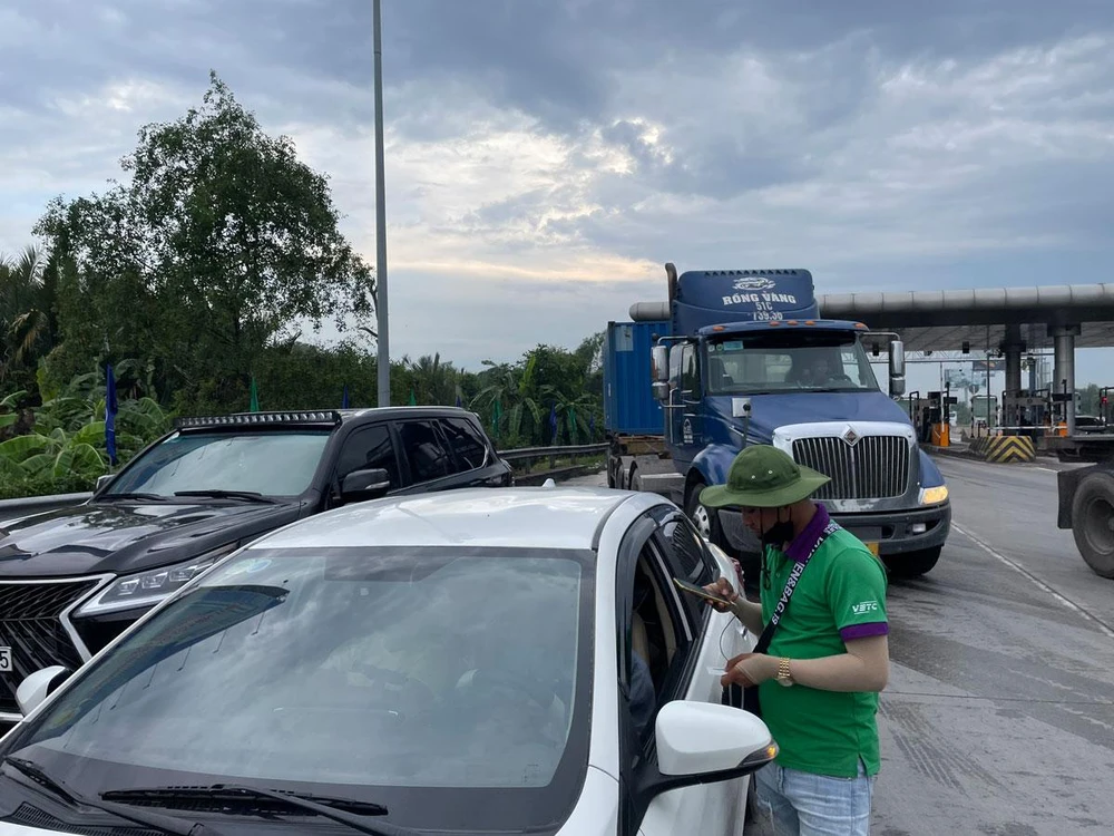 Xe xếp hàng dài chờ dán thẻ ETC ở trạm Long Phước. Ảnh: HV