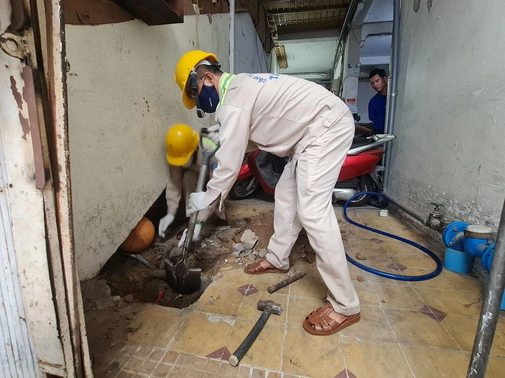 Nhân viên Công ty cổ phần Cấp nước Tân Hòa đang lấp một giếng khoan tại quận Tân Phú ngày 16-6. Ảnh: NC