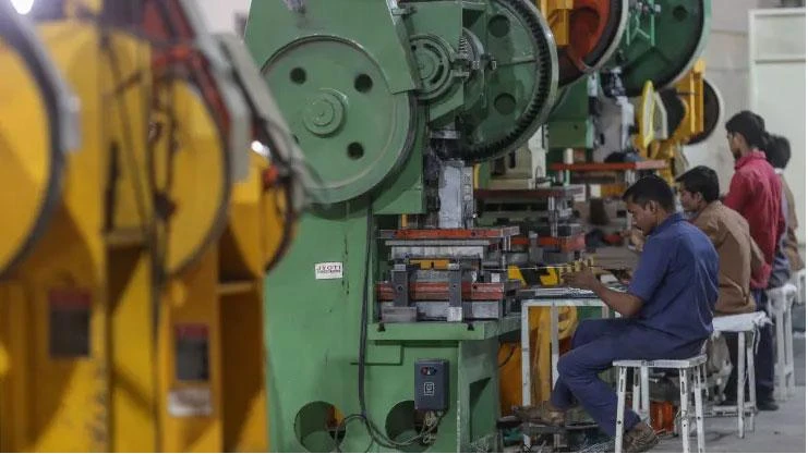 Công nhân xử lý các bộ phận kim loại tại một nhà máy sản xuất bếp nấu ăn của công ty GHG Reduction Technologies Pvt ở bang Maharashtra (Ấn Độ), ngày 13-11. Ảnh: GETTY IMAGES