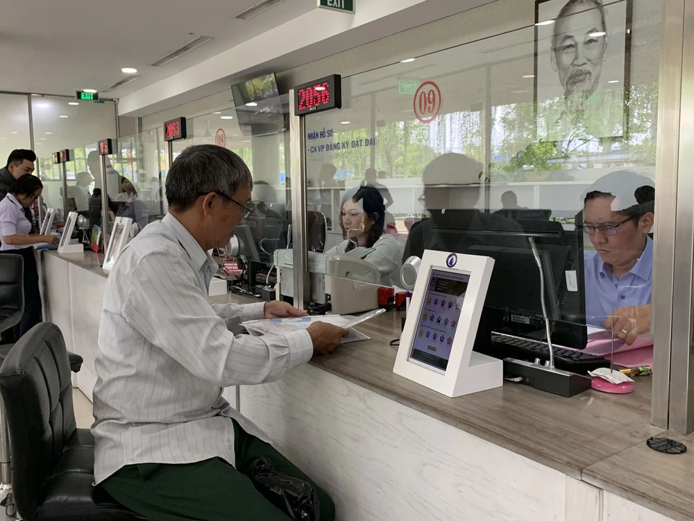 Người dân làm thủ tục hành chính về nhà đất ở bộ phận một cửa, UBND quận 12. Ảnh: VH