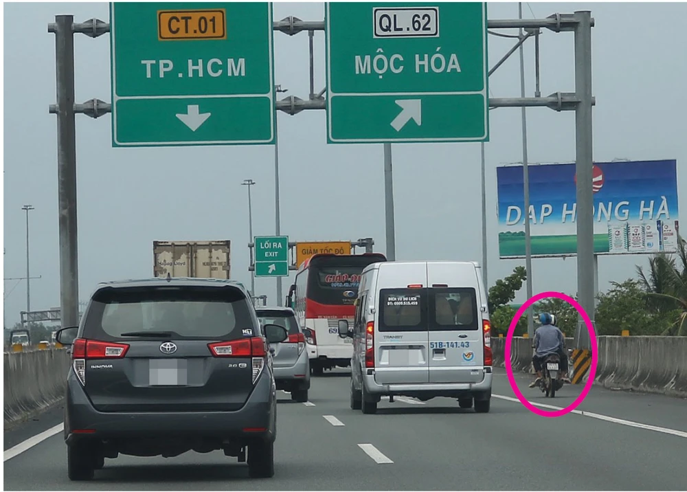 Người dân điều khiển xe máy đi vào đường cao tốc. Ảnh: NGUYỆT NHI