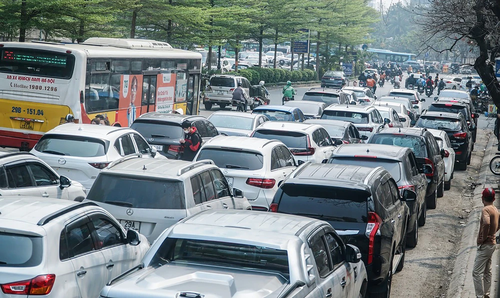 Phía bên ngoài đường Cầu Giấy, đoạn trước cổng Trung tâm Đăng kiểm xe cơ giới số 29-03V (quận Đống Đa, Hà Nội), hàng trăm ô tô nối đuôi nhau xếp thành 2-3 hàng. Ảnh: PHI HÙNG