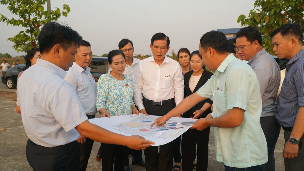 Ông Lương Minh Phúc (áo trắng giữa ảnh), Giám đốc Ban quản lý dự án đầu tư xây dựng các công trình giao thông TP và bà Nguyễn Thị Lệ , Chủ tịch HĐND TP (áo hoa), khảo sát tuyến đường vành đai 3 TP.HCM. Ảnh: NGUYỄN TIẾN