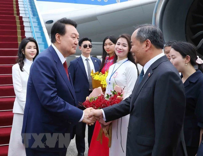 Thứ trưởng Bộ Ngoại giao Nguyễn Minh Vũ đón Tổng thống Hàn Quốc Yoon Suk-yeol và phu nhân tại sân bay quốc tế Nội Bài ngày 22-6. Ảnh: TTXVN