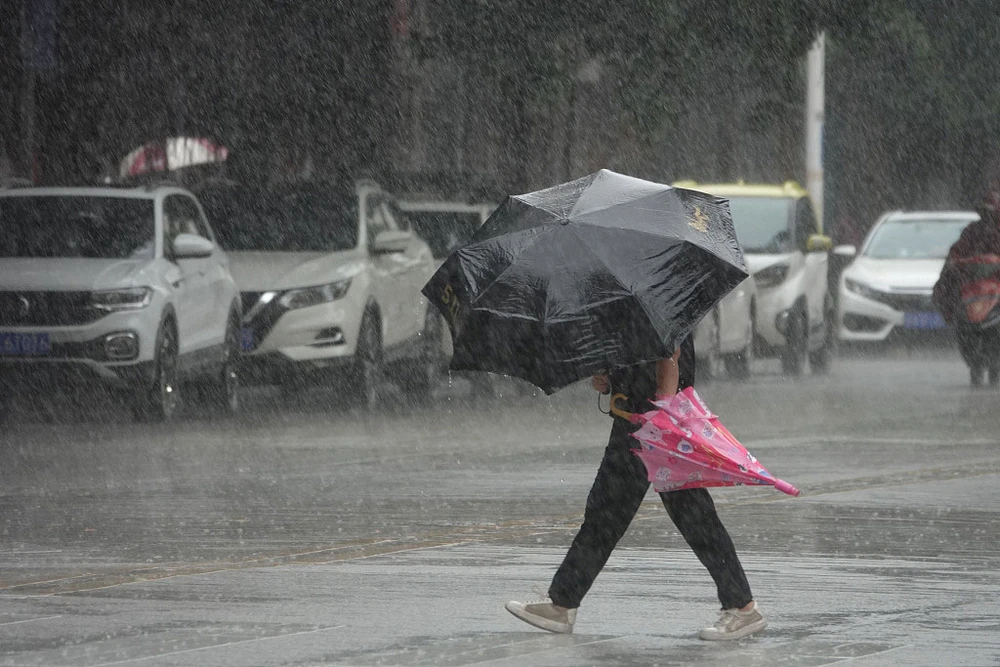 Một phụ nữ đi dưới trời mưa lớn do ảnh hưởng của bão Talim tại Nam Ninh, Khu tự trị dân tộc Choang Quảng Tây ngày 18-7. Ảnh: CGTN