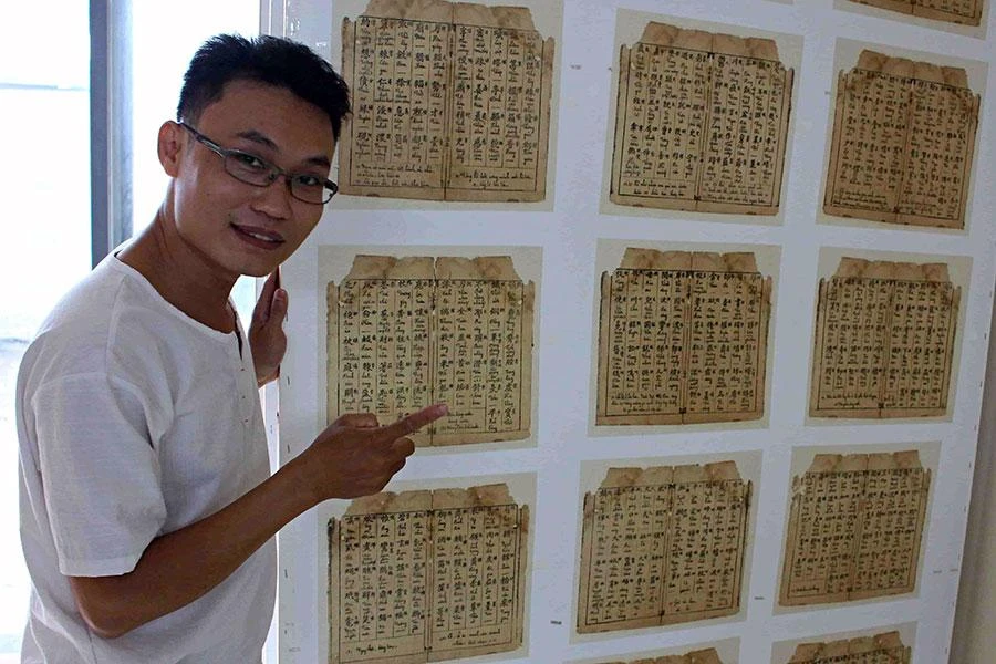 Bùi Tiến Phúc bên những trang tư liệu Hán Nôm cổ quý hiếm đã được anh phục chế thành công. Ảnh: NGUYỄN SƠN