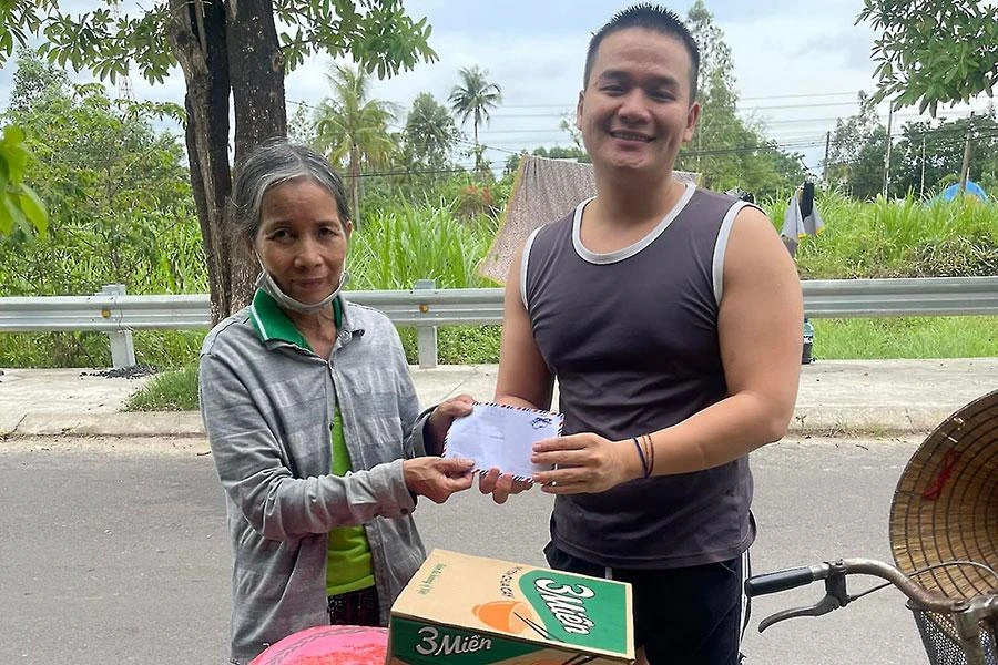 Anh Lưu trao tiền hỗ trợ cho một hoàn cảnh khó khăn. Ảnh: TÚ NGÂN
