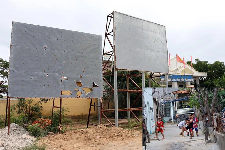 Bảng quy hoạch dự án nhà máy hạt nhân tại xã Phước Dinh, huyện Thuận Nam, tỉnh Ninh Thuận rách nát sau sáu năm tạm dừng và những đứa trẻ vui chơi trong làng chài thôn Vĩnh Trường (ảnh nhỏ). Ảnh: HUỲNH HẢI