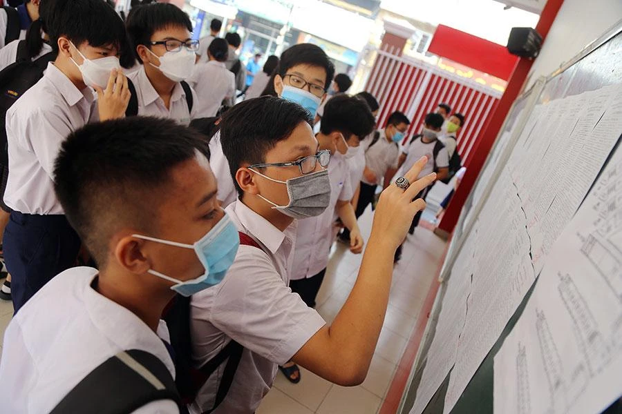 Các thí sinh xem danh sách phòng thi tại điểm thi Trường THCS Âu Lạc (quận Tân Bình, TP.HCM) vào sáng 10-6. Ảnh: HOÀNG GIANG