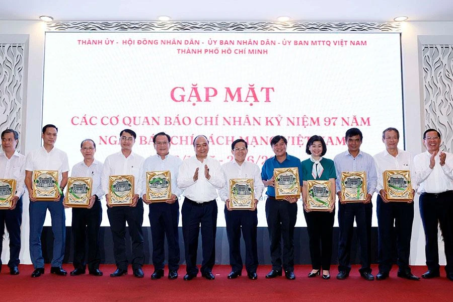 Chủ tịch nước Nguyễn Xuân Phúc tặng quà lưu niệm cho các tổng biên tập, trưởng các cơ quan báo chí, nhà báo tiêu biểu trên địa bàn TP.HCM. Ảnh: L.THOA