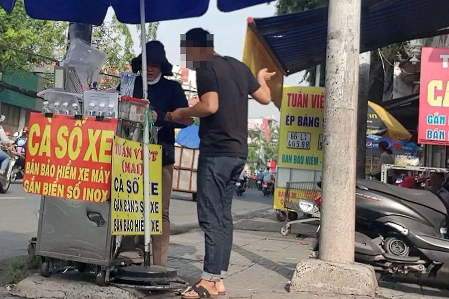 Được một người mặc đồ dân phòng chỉ, chúng tôi đến gặp người phụ nữ muốn làm lẹ CCCD và bà chỉ vào tiệm Tuấn Việt 588 bên hông trụ sở công an. Ảnh: NT - NY