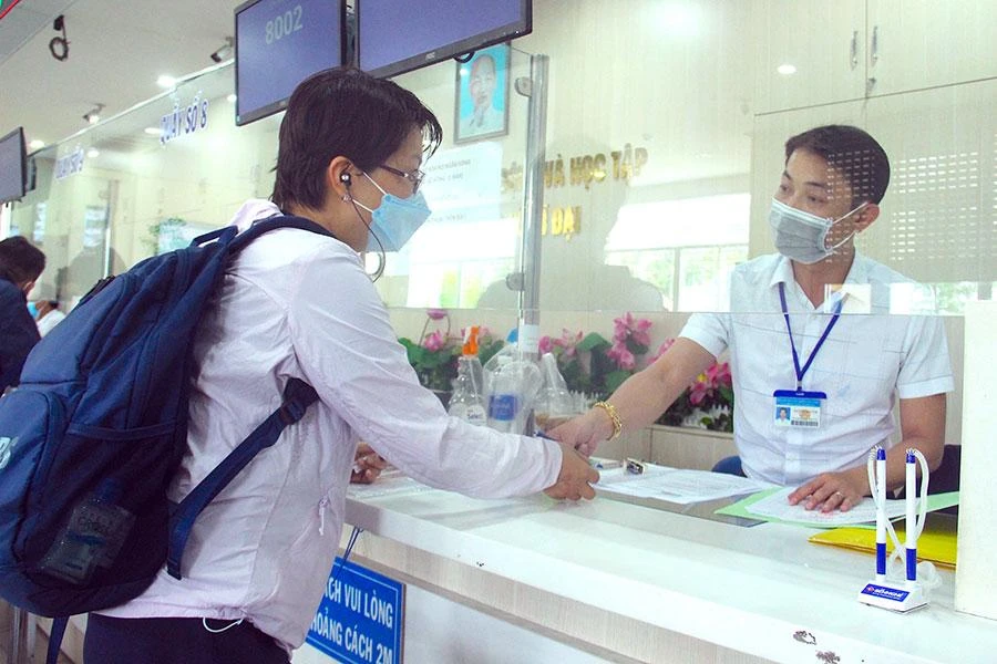 Cán bộ quận Bình Tân, TP.HCM hướng dẫn, giải quyết các thủ tục cho người dân. Ảnh: LÊ THOA