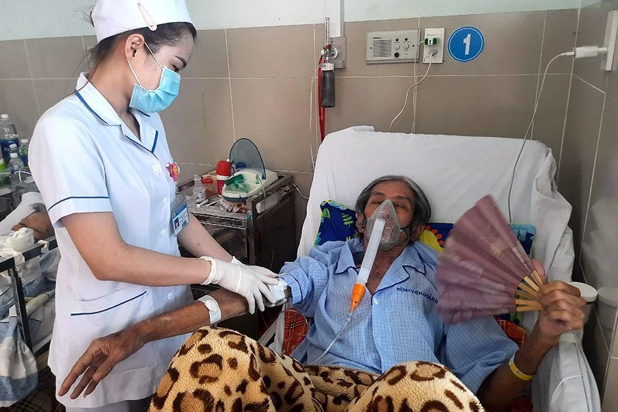 Một bệnh nhân nặng đang được điều dưỡng BV quận 11, TP.HCM kiểm tra sinh hiệu. Ảnh: TRẦN NGỌC