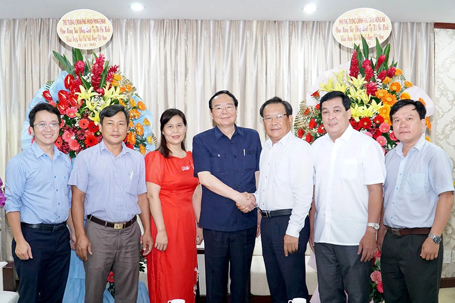 PGS-TS Nguyễn Văn Cường, Phó Cục trưởng Cục Hành chính - Quản trị II, Văn phòng Chính phủ (giữa), chuyển lẵng hoa, lời chúc mừng của Thủ tướng Phạm Minh Chính và Phó Thủ tướng Trần Hồng Hà đến báo Pháp Luật TP.HCM. Ảnh: BẢO PHƯƠNG