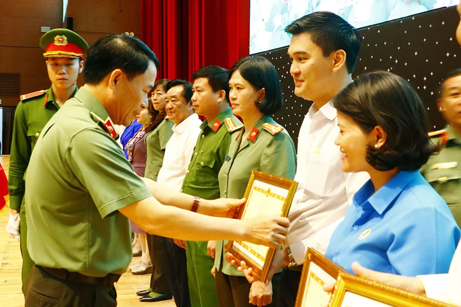 Bộ trưởng Bộ Công an đã tặng bằng khen cho bốn tập thể và bảy cá nhân có thành tích xuất sắc trong năm năm thực hiện mô hình Đội công nhân xung kích tự quản về an ninh trật tự trong doanh nghiệp tại Bình Dương (giai đoạn 2018-2022). Ảnh: LÊ ÁNH
