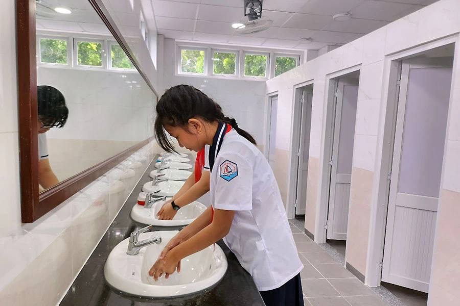 Học sinh Trường THCS Ngô Quyền (quận Tân Bình) sử dụng nhà vệ sinh mới, sạch sẽ. Ảnh: NGUYỄN QUYÊN