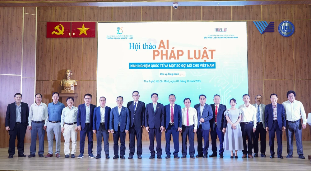 Lãnh đạo Trường ĐH Kinh tế - Luật, ĐH Quốc gia TP.HCM, báo Pháp Luật TP.HCM cùng các chuyên gia, khách mời chụp ảnh lưu niệm tại hội thảo. Ảnh: THUẬN VĂN