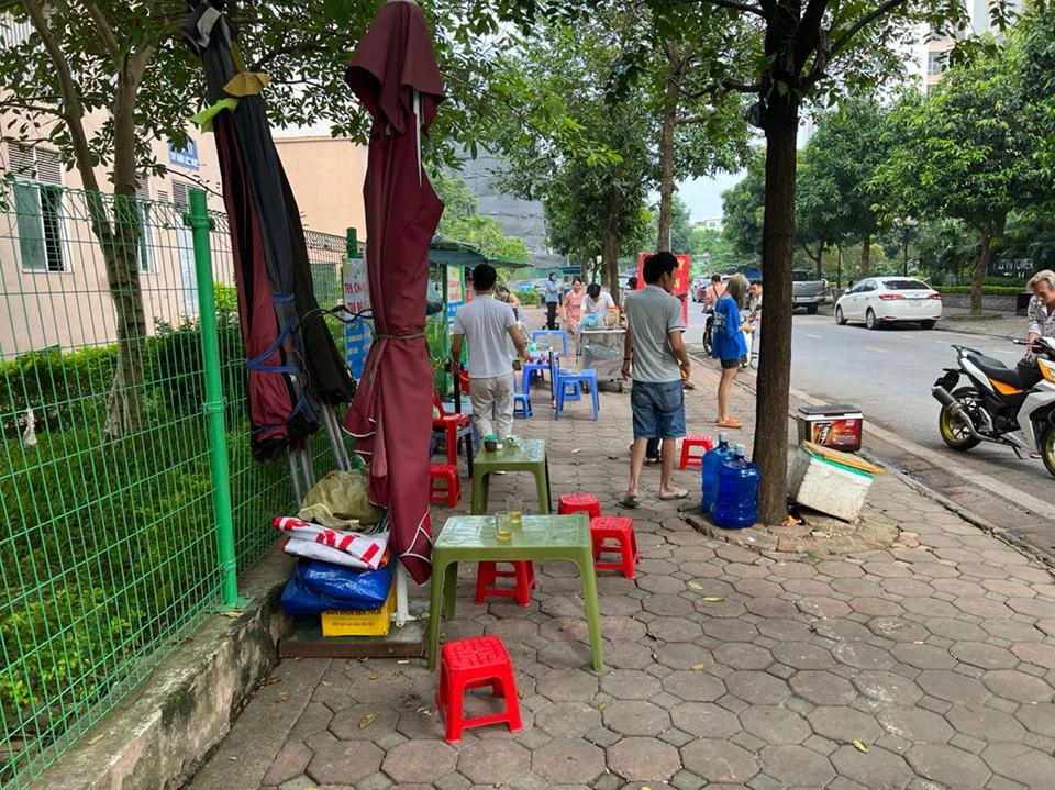 Chủ các quán nước giải khát tại khu vực vỉa hè hồ Linh Đàm (phường Hoàng Liệt) dọn dẹp khi biết lực lượng chức năng xử lý tình trạng lấn chiếm lòng đường, vỉa hè.