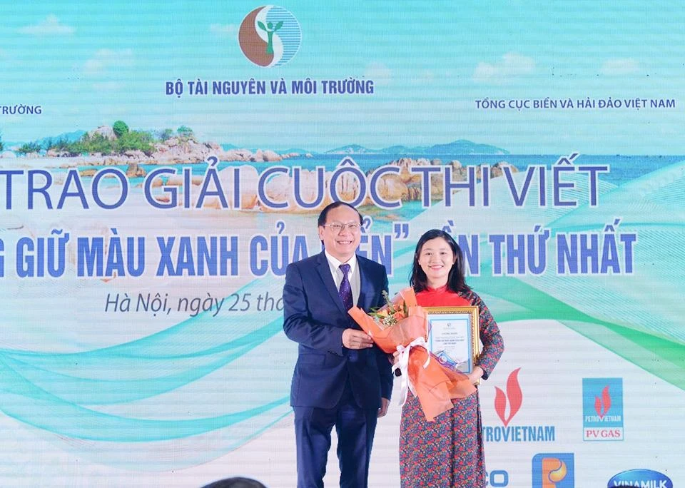 Thứ trưởng Bộ Tài nguyên và Môi trường Lê Công Thành trao Giải Nhất của cuộc thi cho Nhà văn, nhà báo Mai Lữ (Lữ Thị Mai) đến từ Báo Nhân dân với tác phẩm “Thở đi nào biển ơi”. (Ảnh: TP)